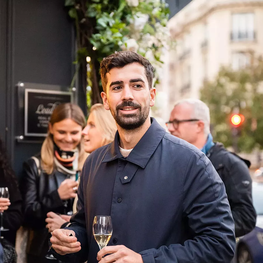 Dark-haired man holding a glass of Champagne