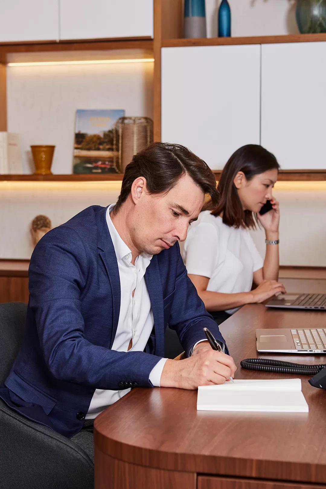 Un collaborateur du groupe Unio en train d'écrire sur un bureau d'une agence immobilière de luxe à Paris