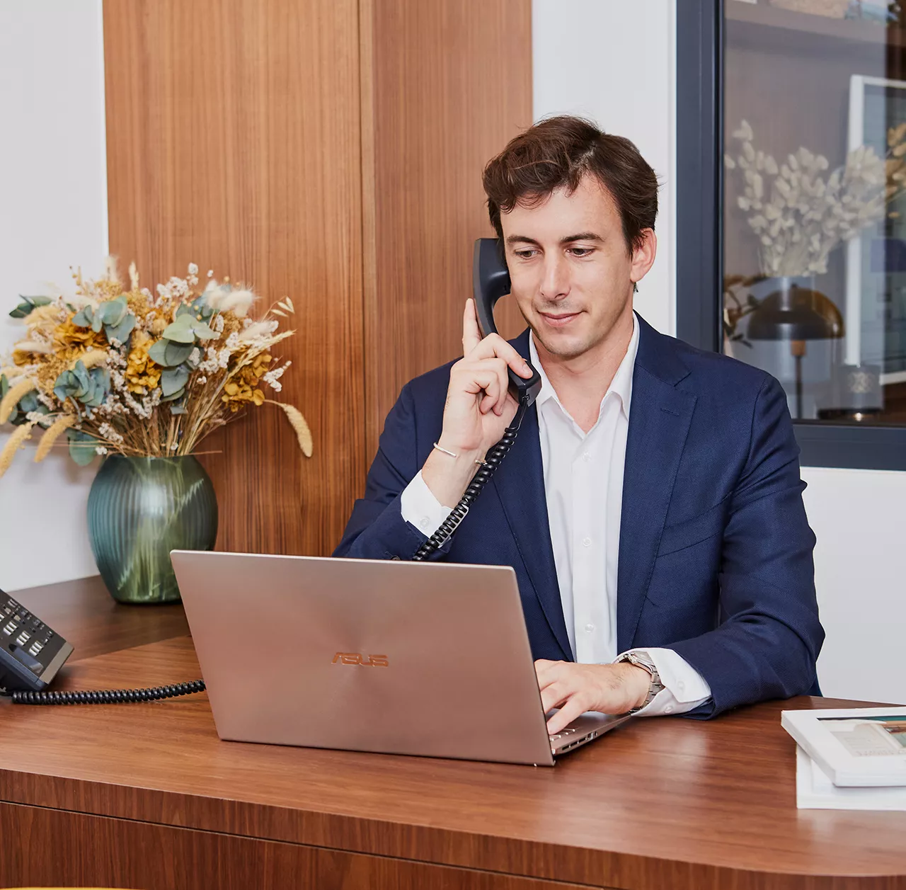 Agent immobilier Junot au téléphone avec un vendeur Junot devant son ordinateur