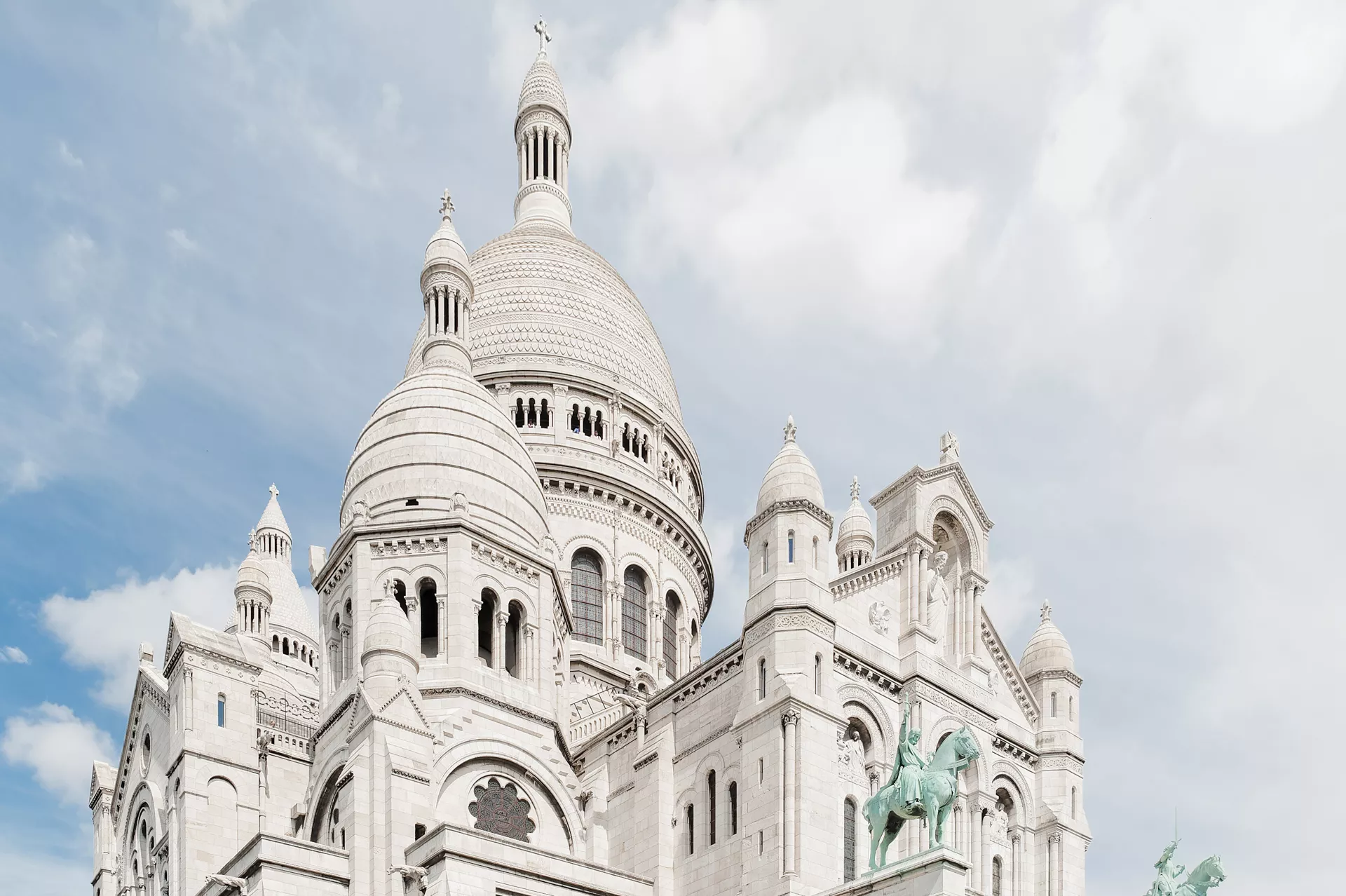 Vue emblématique de la basilique du Sacré-Cœur, dominant Paris depuis la butte Montmartre dans le 18ᵉ arrondissement.