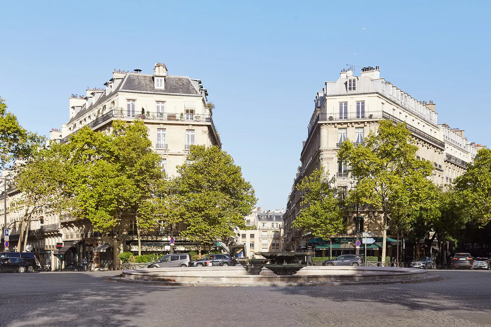 Place Victor Hugo dans le 16ᵉ arrondissement de Paris, baignée de soleil, entourée d’immeubles haussmanniens et de verdure.