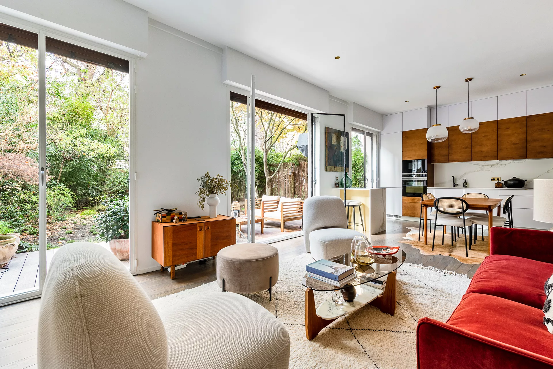 Intérieur d’un appartement lumineux avec accès direct à un rez-de-jardin verdoyant dans le 16ᵉ arrondissement de Paris.