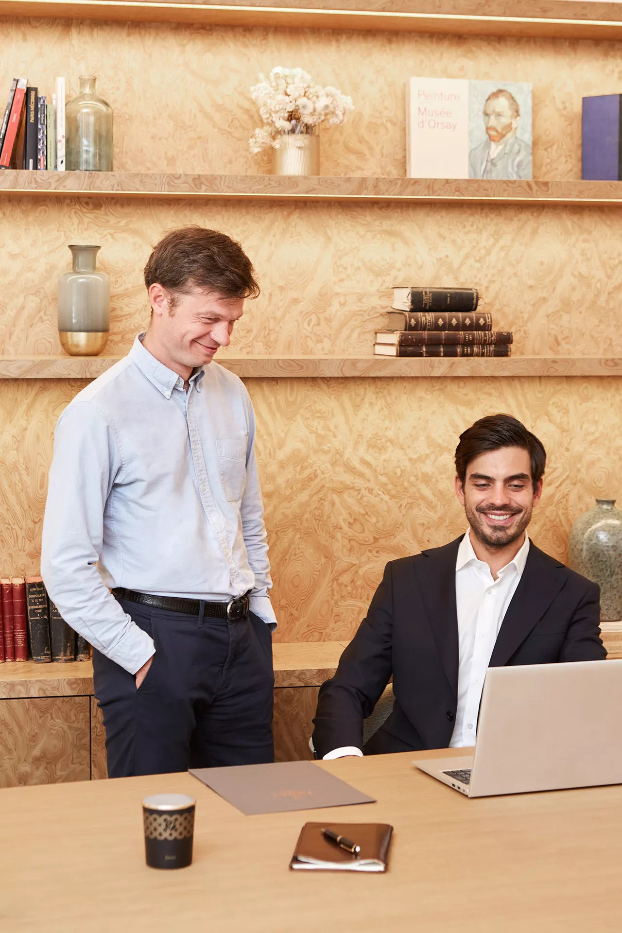 A woman sitting behind a computer with a man beside her