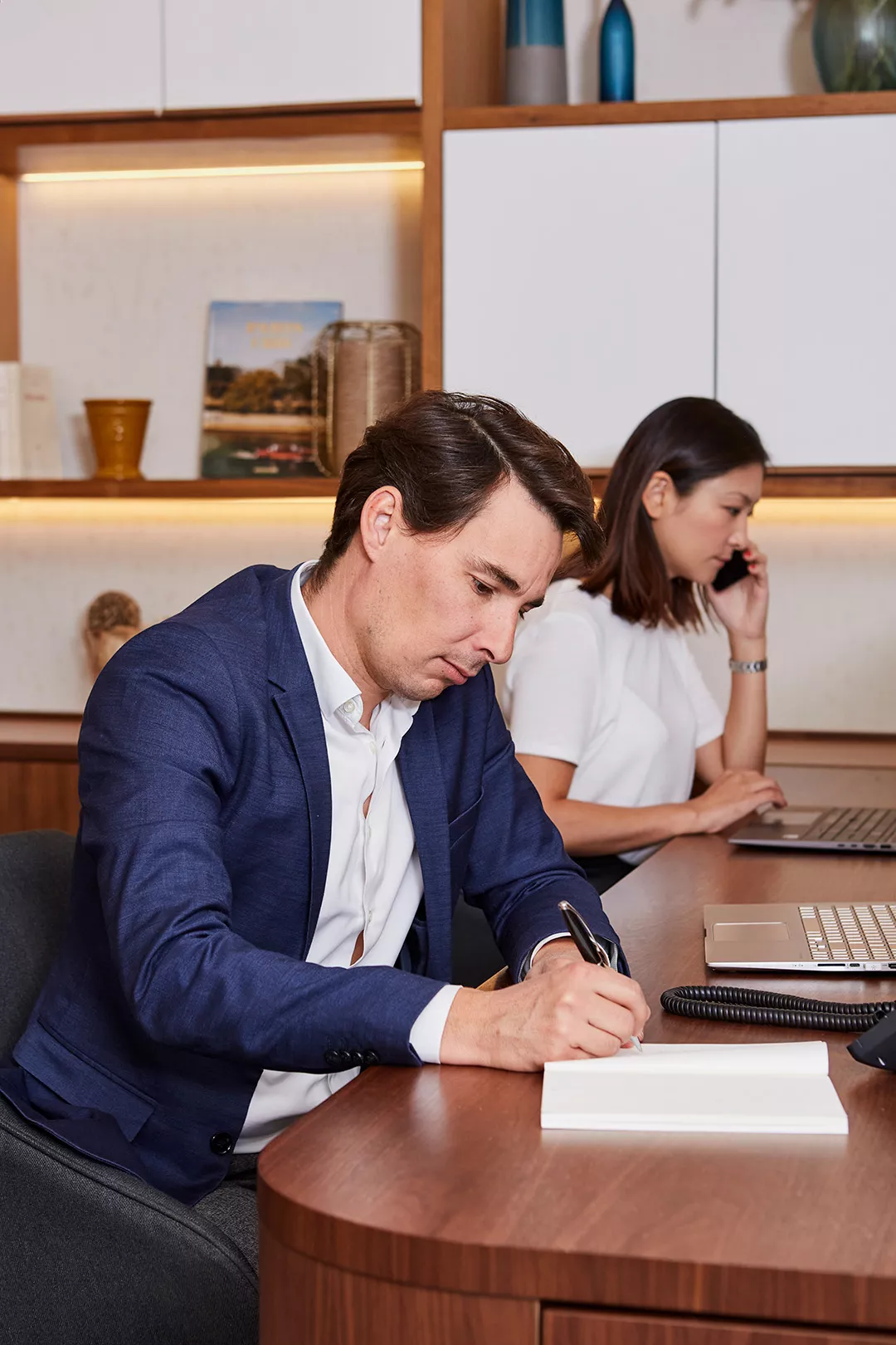 Two Junot consultants smiling behind a laptop