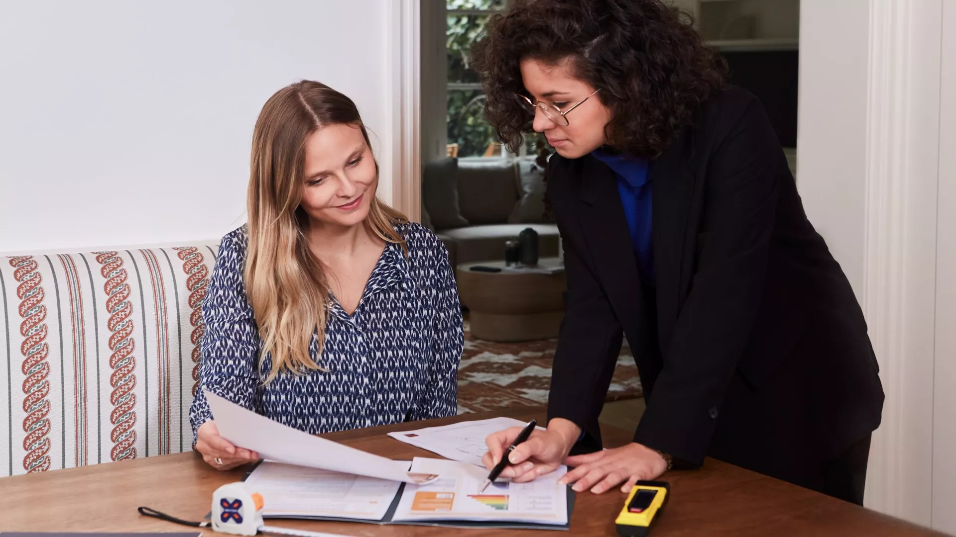 Photo of an architect and a Junot consultant studying the renovation plan of an apartment