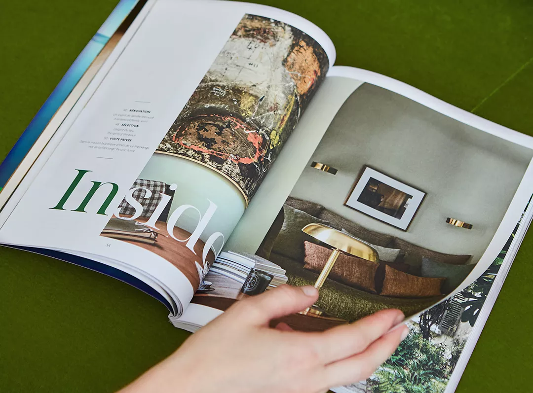 Personne feuilletant me Junot Magazine sur un fond vert