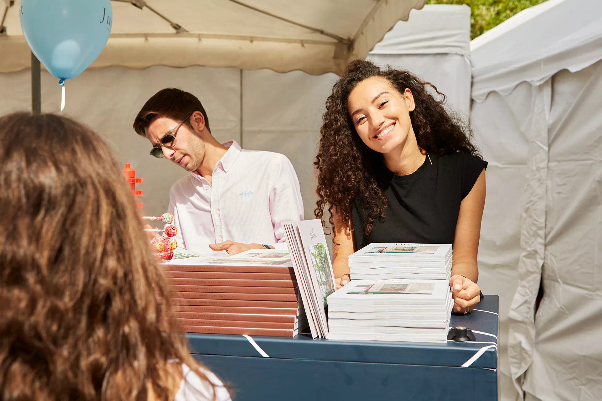 Un consultante Junot souriante en train de distribuer le Junot Magazine