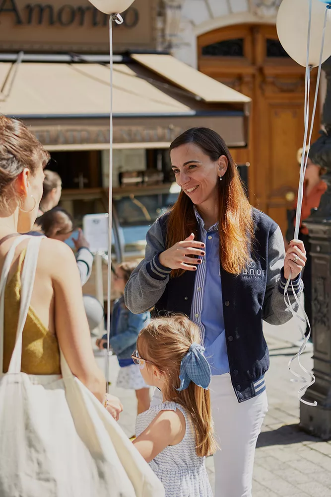 A Junot consultant chatting with a client and her little daughter, who is holding a balloon