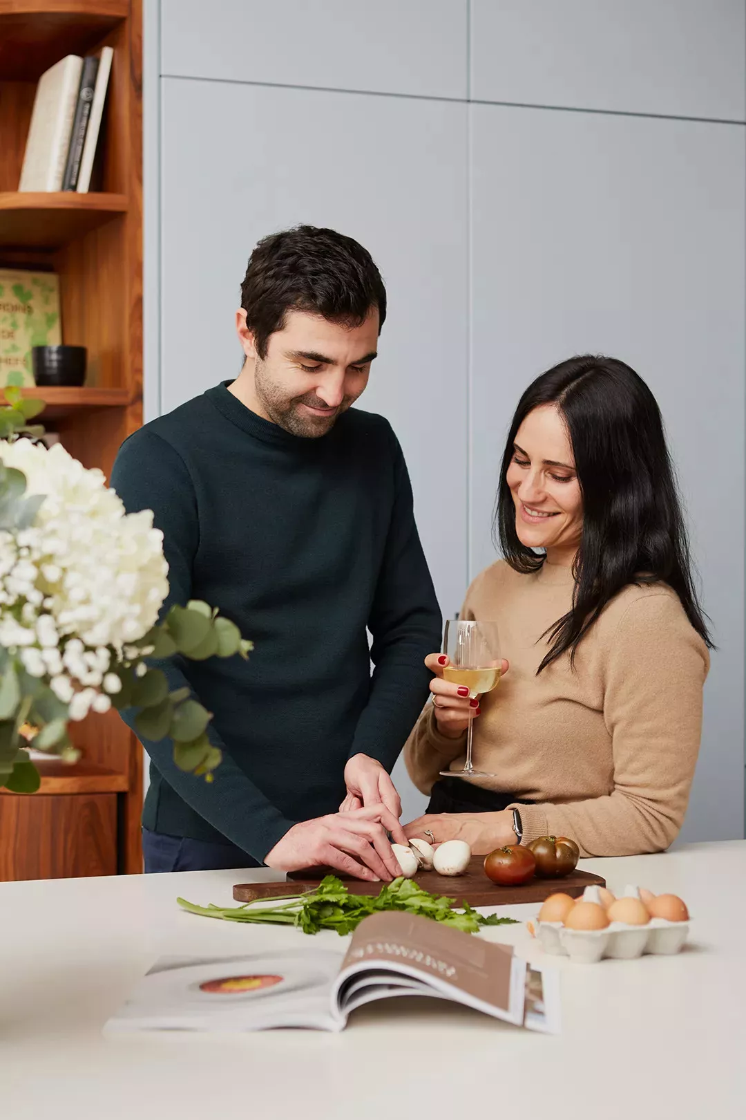 Two Junot consultants leafing through the Junot Magazine in a kitchen